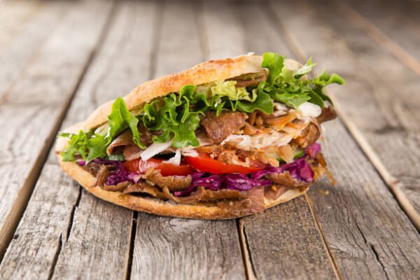 close up of kebab sandwich on wooden background